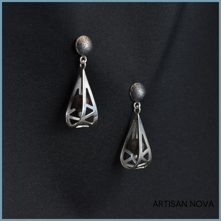 srebrne-kolczyki-wiszace-lawa-geometria-na-tle.png
