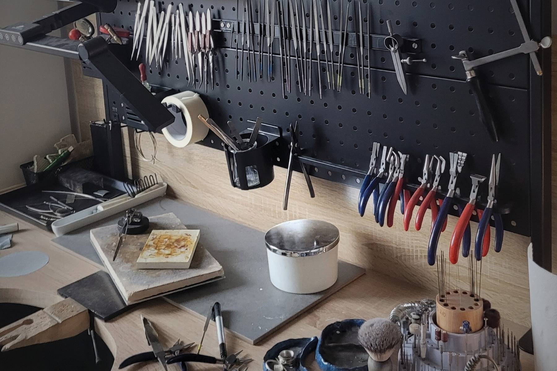 Stanowisko pracy w pracowni złotniczej – narzędzia jubilerskie i blat roboczy